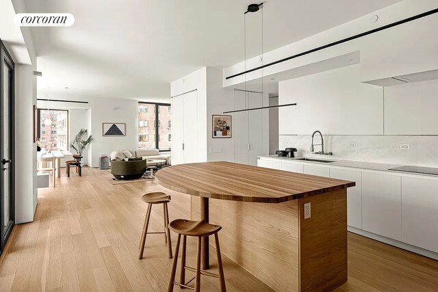 bar with white double oven, visible vents, a sink, and light wood-style floors