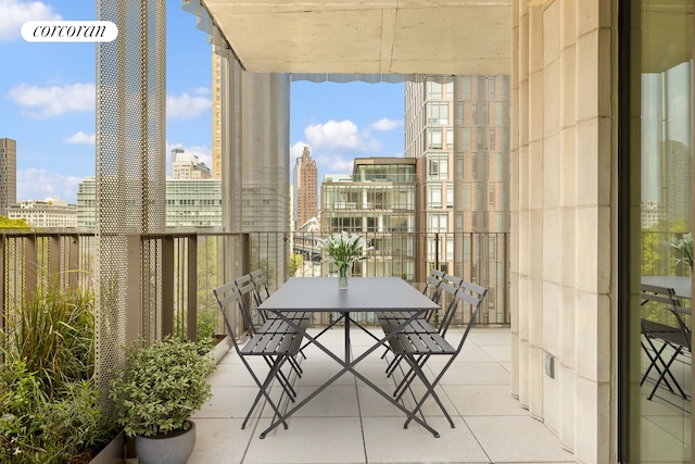 balcony with a view of city and outdoor dining area