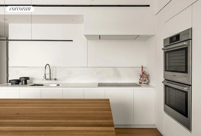 9 Chapel St Phb, Phb, New York City, NY 11201 - kitchen with a sink, black electric stovetop, stainless steel double oven, modern cabinets, and white cabinetry