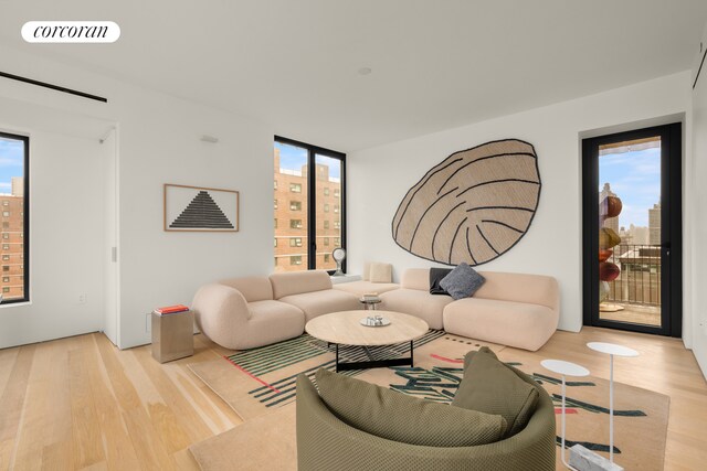 living area with decorative columns, a view of city, visible vents, and wood finished floors