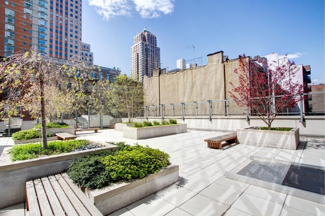 view of property's community featuring a view of city, a patio, and fence