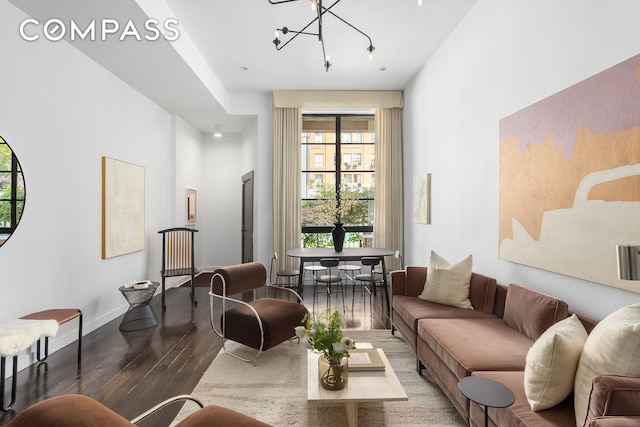 living room with baseboards, wood finished floors, and a chandelier