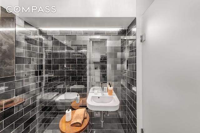 bathroom with decorative backsplash, tile walls, toilet, and a sink