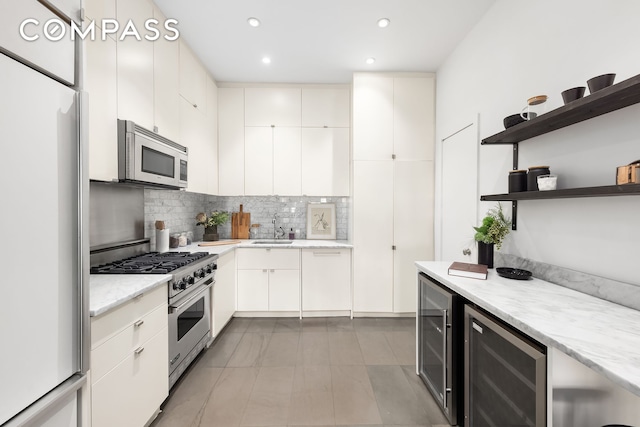 kitchen with a sink, open shelves, tasteful backsplash, wine cooler, and appliances with stainless steel finishes