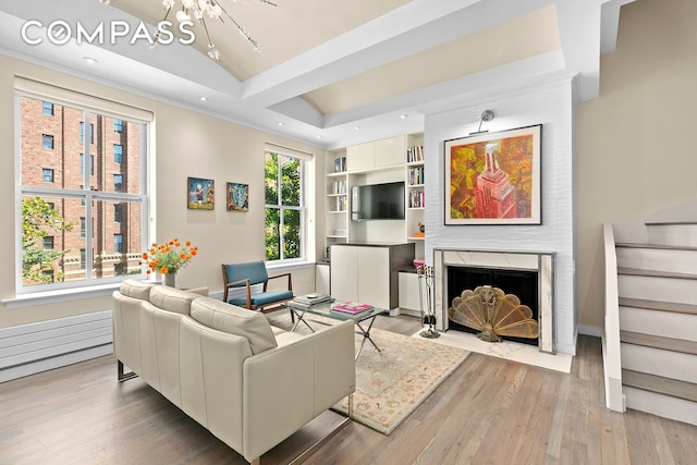 living room with built in features, recessed lighting, a premium fireplace, wood finished floors, and stairs