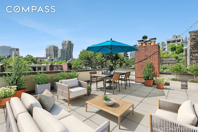 view of patio with outdoor dining space, an outdoor living space, and a view of city