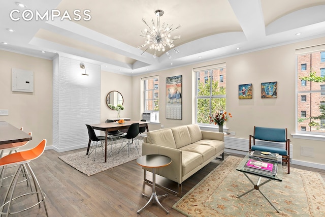 living room featuring wood finished floors, baseboards, an inviting chandelier, electric panel, and a raised ceiling