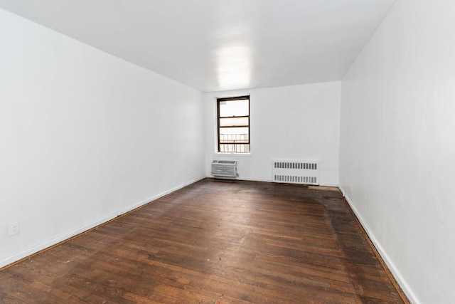 unfurnished room featuring radiator and dark hardwood / wood-style floors