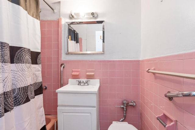 bathroom with vanity, tile walls, and toilet