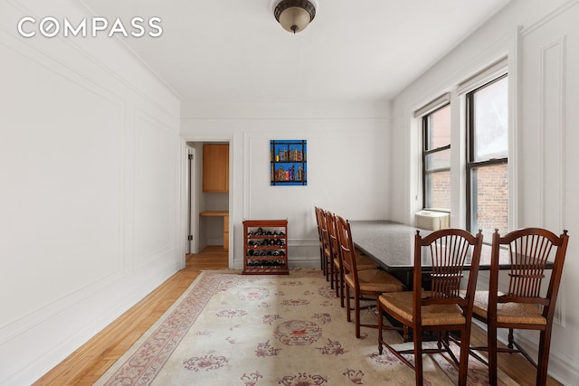 dining room with a decorative wall and light wood finished floors