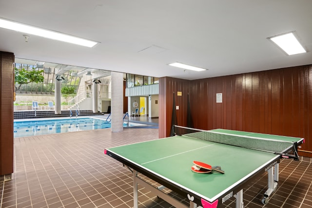 game room with wood walls and tile patterned floors