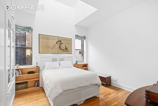 bedroom with light wood finished floors and baseboards