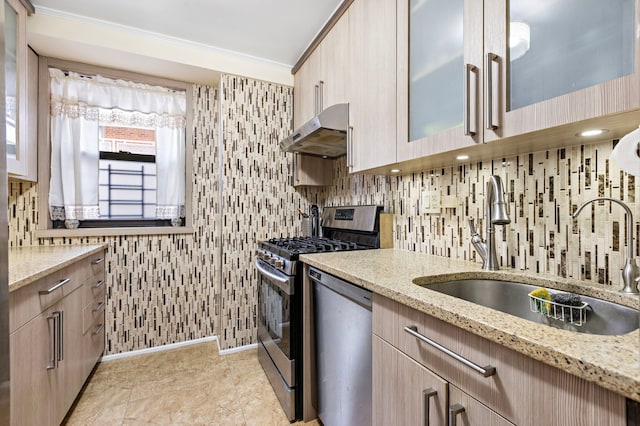 61-35 98th St Unit 15-E, New York City, NY 11374 - kitchen with under cabinet range hood, appliances with stainless steel finishes, light stone counters, light brown cabinets, and ornamental molding