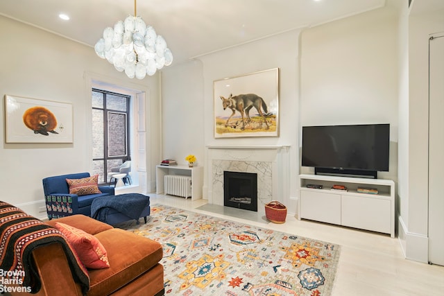 living room with a fireplace, radiator, light wood-type flooring, and a notable chandelier