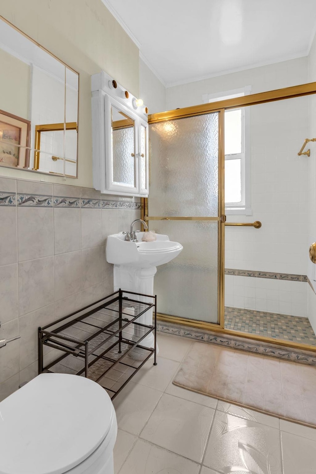 full bath with tile walls, a stall shower, toilet, ornamental molding, and tile patterned floors