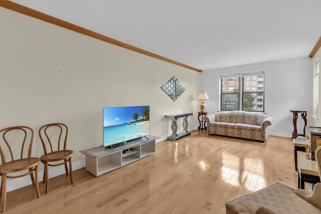 living room featuring crown molding, wood finished floors, and baseboards