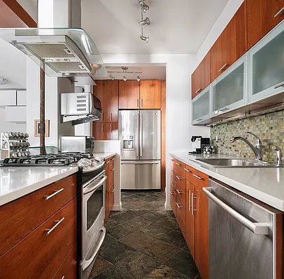 kitchen featuring appliances with stainless steel finishes, track lighting, decorative backsplash, sink, and island range hood