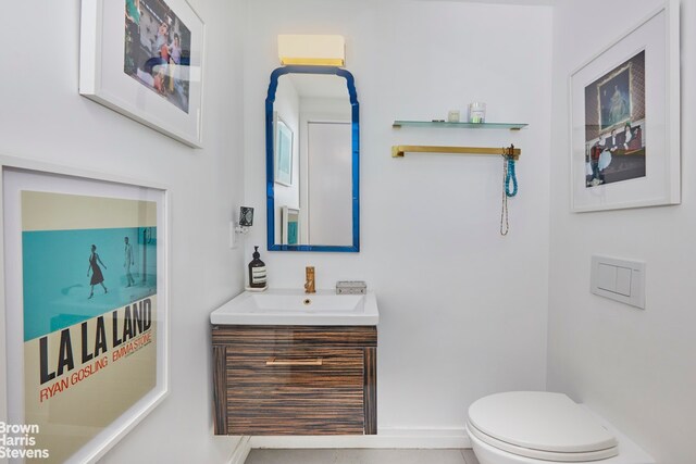 bathroom featuring toilet, vanity, plenty of natural light, and a shower with door