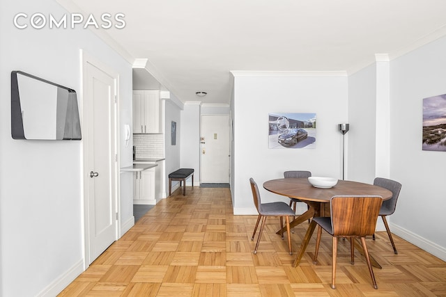 dining space featuring crown molding and baseboards