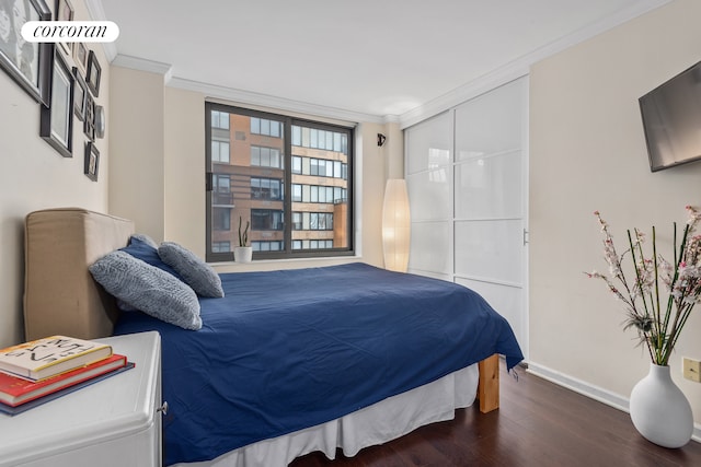 bedroom with baseboards, wood finished floors, and ornamental molding