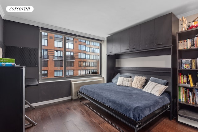 bedroom featuring visible vents, baseboards, ornamental molding, and hardwood / wood-style flooring