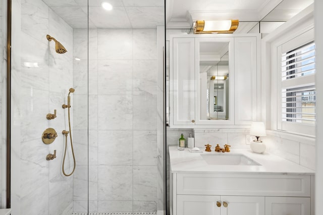 full bath with tiled shower, vanity, and crown molding