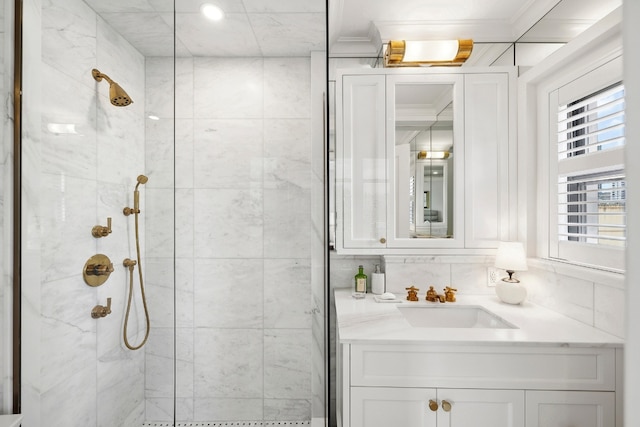 bathroom featuring tile walls, tiled shower, vanity, and ornamental molding