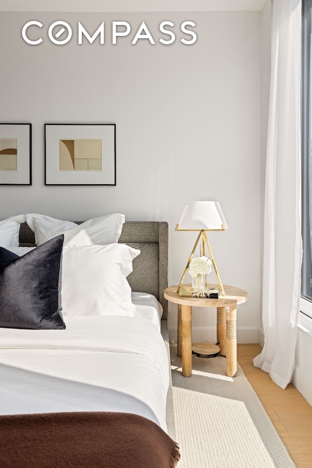 bedroom with baseboards and wood finished floors