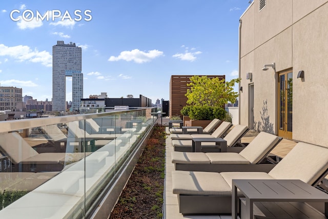 view of patio featuring visible vents, an outdoor hangout area, a view of city, and a balcony