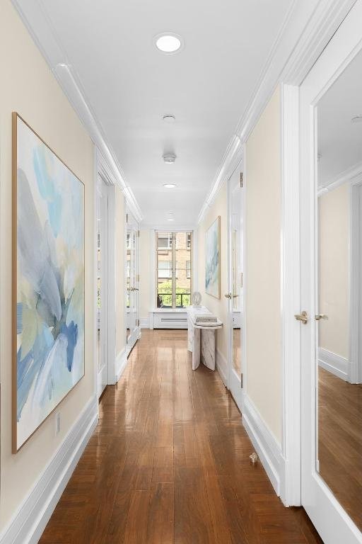 hallway with dark hardwood / wood-style floors and ornamental molding