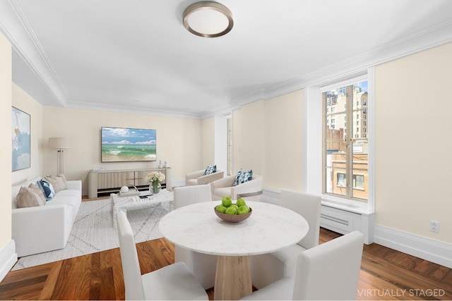 dining space with hardwood / wood-style floors and ornamental molding