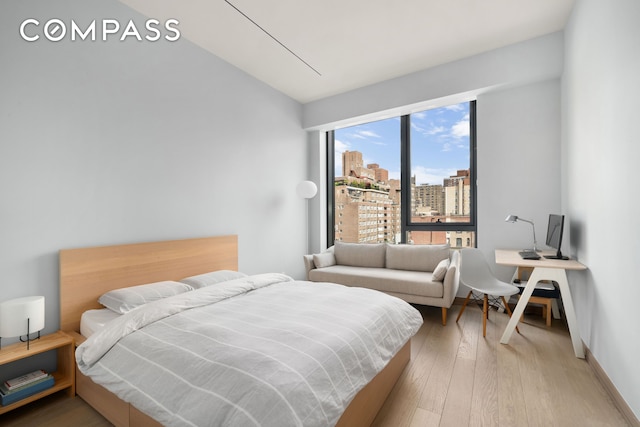 bedroom featuring hardwood / wood-style flooring and baseboards