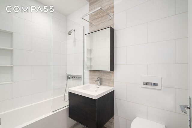 full bathroom featuring toilet, tile walls, and vanity