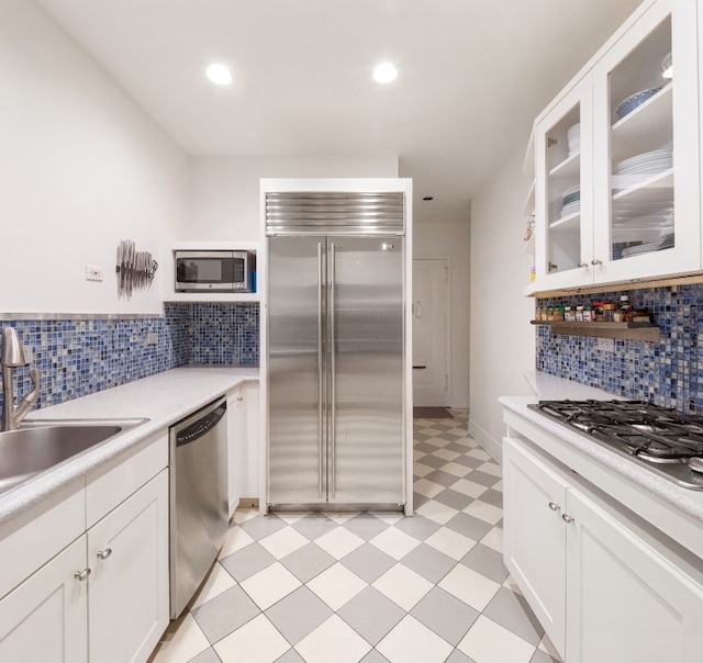 kitchen featuring backsplash, sink, white cabinets, and appliances with stainless steel finishes