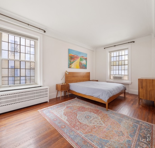 bedroom featuring hardwood / wood-style flooring, crown molding, and radiator