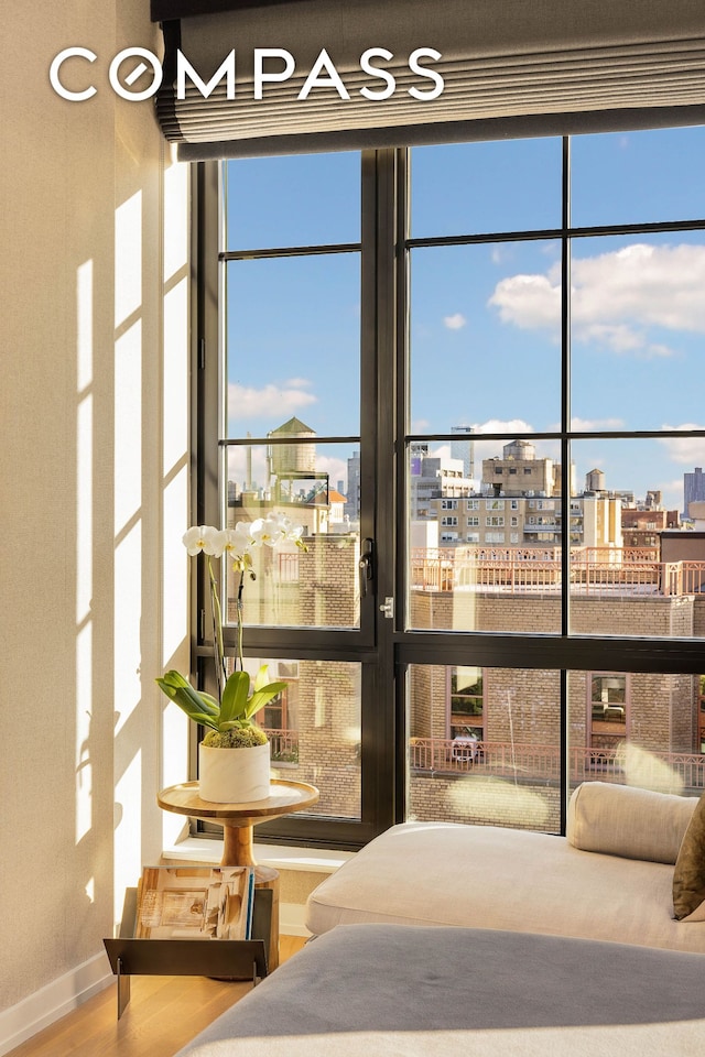 bedroom featuring baseboards, a city view, and wood finished floors