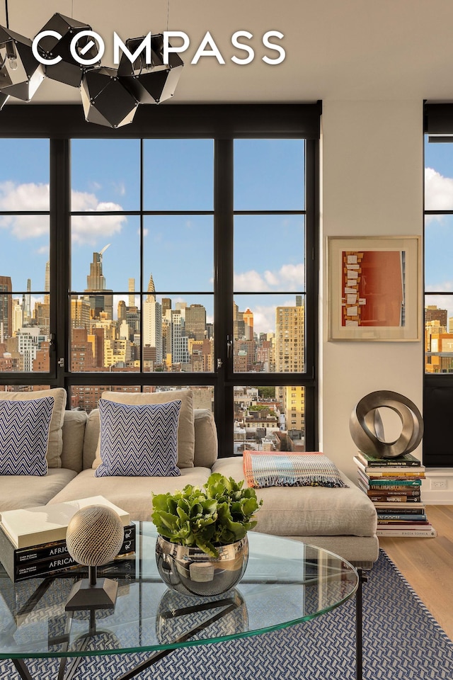 living area featuring a view of city, a wall of windows, and wood finished floors