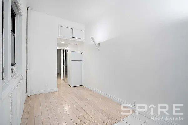 spare room featuring light wood-style flooring and baseboards