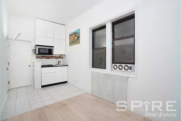 kitchen with sink, light tile patterned floors, and white cabinets