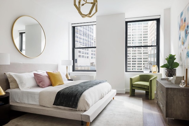 bedroom featuring multiple windows, baseboards, and wood finished floors