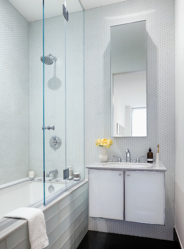 full bath with tiled shower / bath combo, vanity, and tile patterned floors