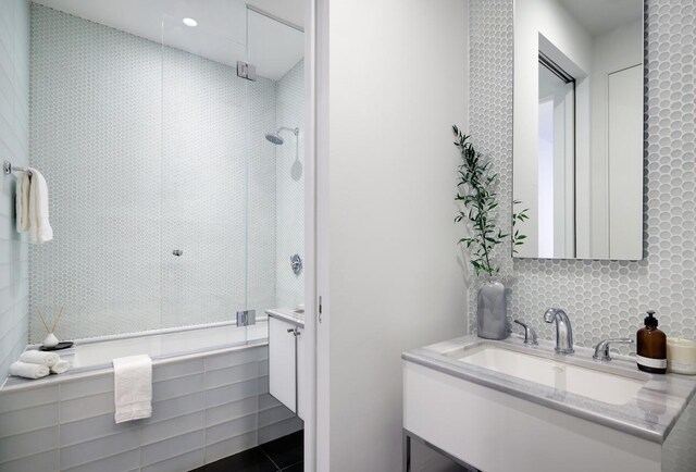 bathroom featuring tiled shower and vanity