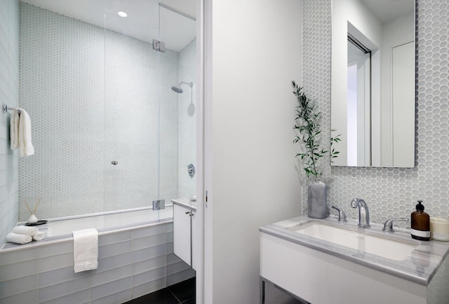 full bathroom featuring a tile shower and vanity