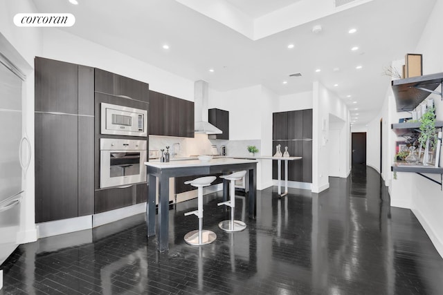 kitchen featuring modern cabinets, stainless steel appliances, recessed lighting, and wall chimney exhaust hood