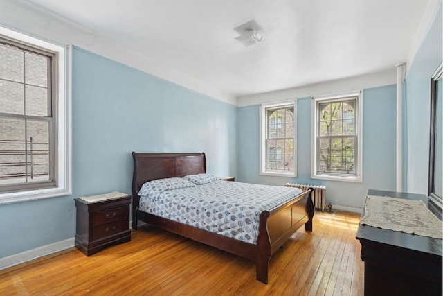 bedroom with radiator and light hardwood / wood-style floors