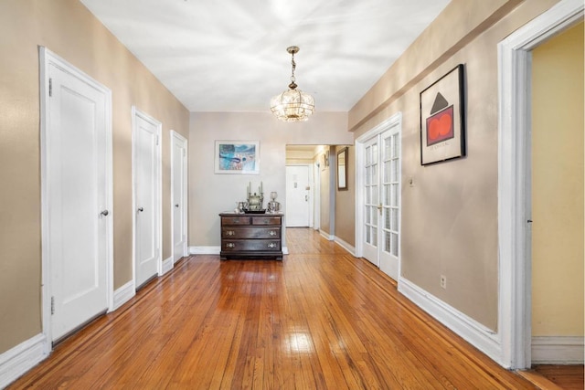 hall featuring hardwood / wood-style flooring and a chandelier