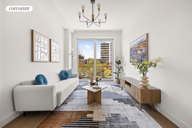 sitting room with an inviting chandelier, visible vents, baseboards, and wood finished floors