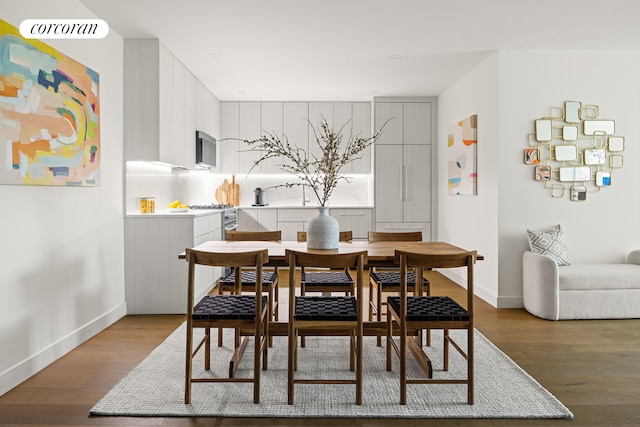 dining space with baseboards and wood finished floors