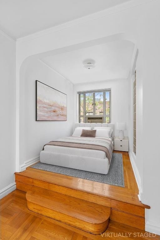 bedroom with parquet floors and crown molding