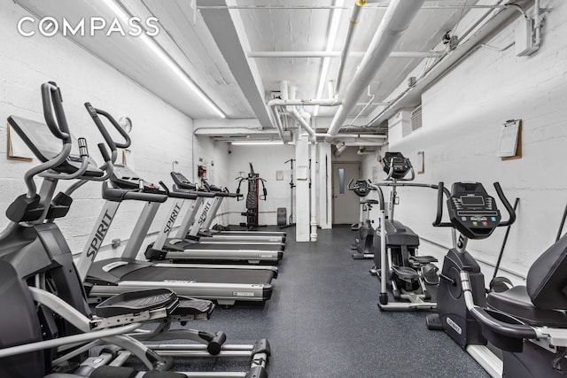 exercise room featuring concrete block wall